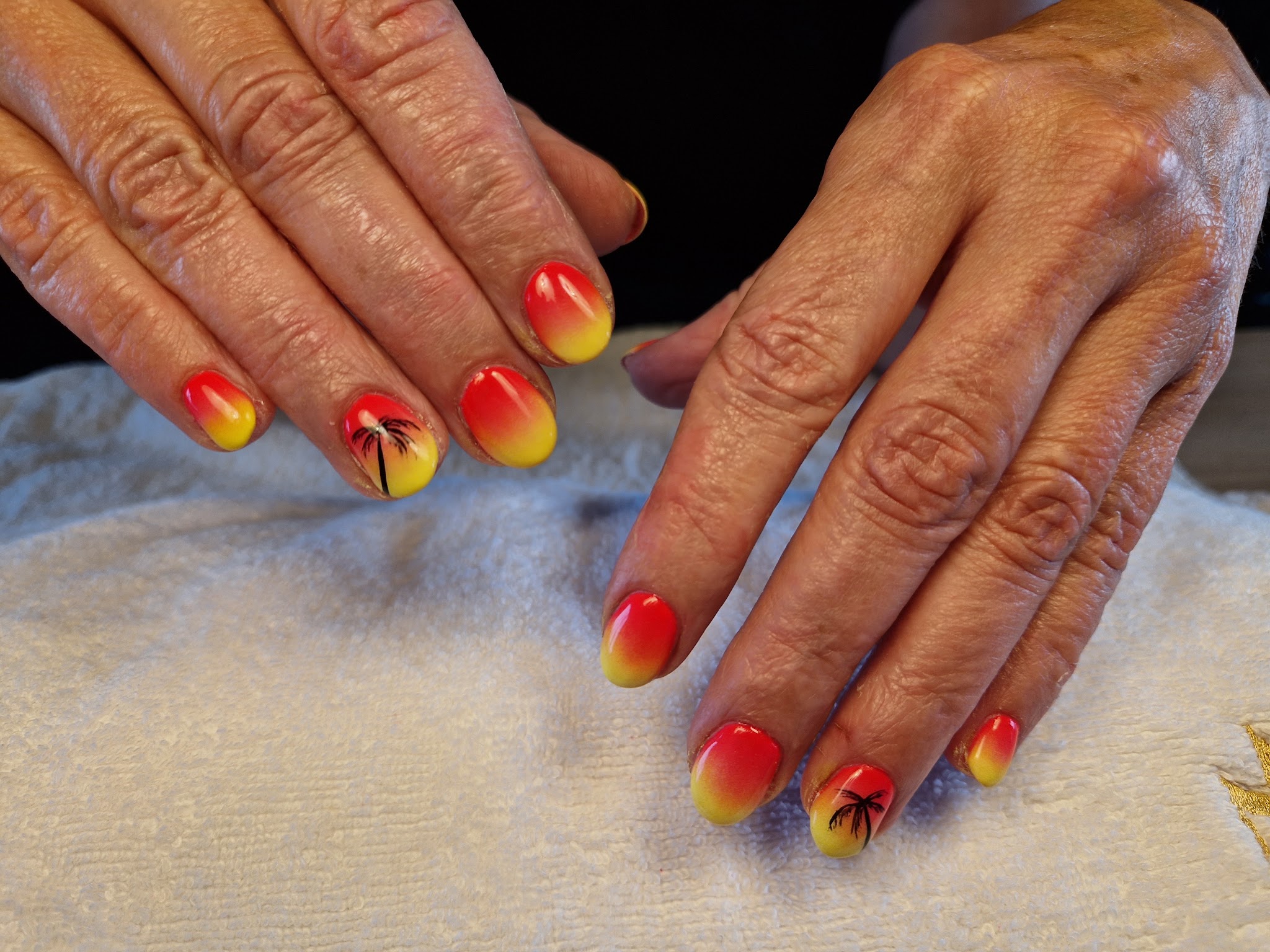 Zomerse nagels in geel en oranje met kleine palmbomen