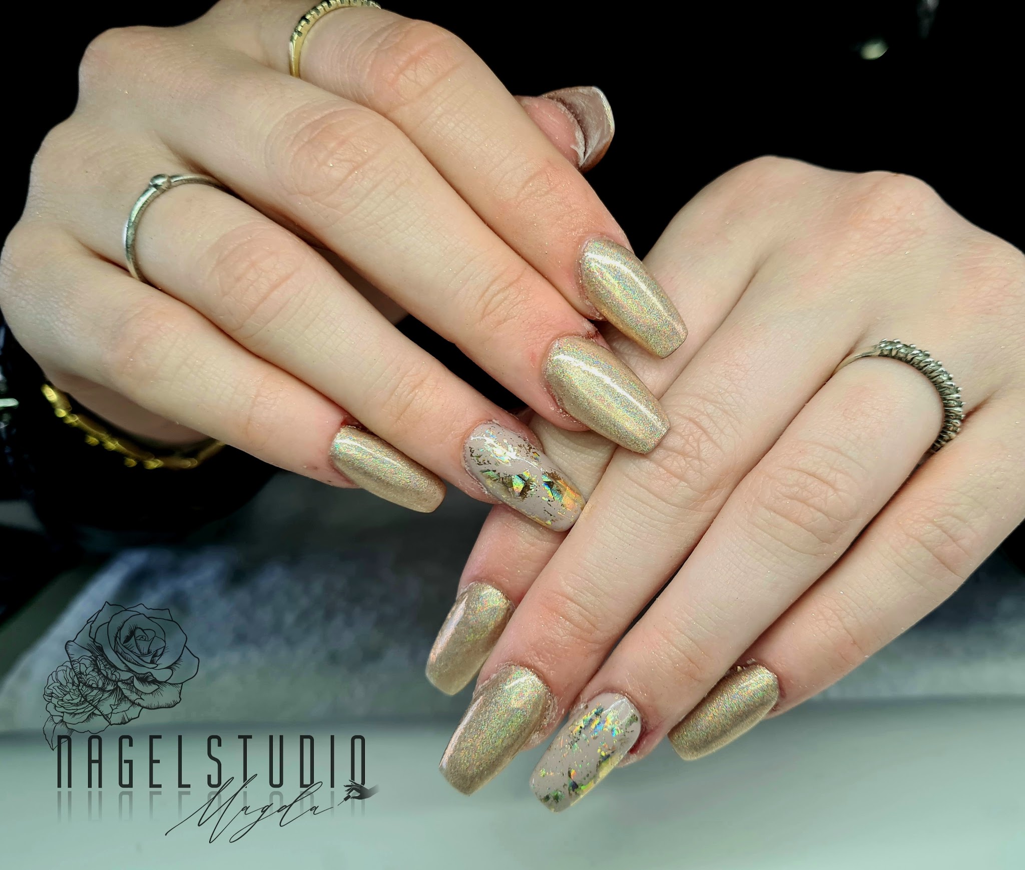 Nagels met een goudgroene glans en bloemversiering