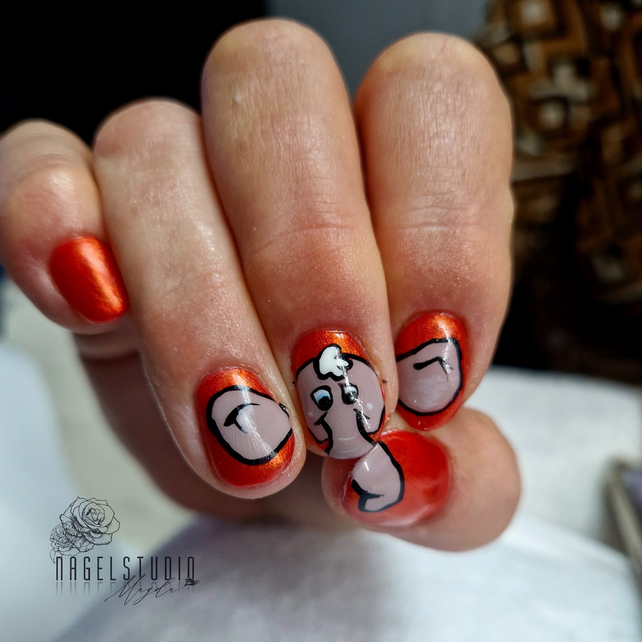 Nagels met oranje glans en kleine getekende figuren